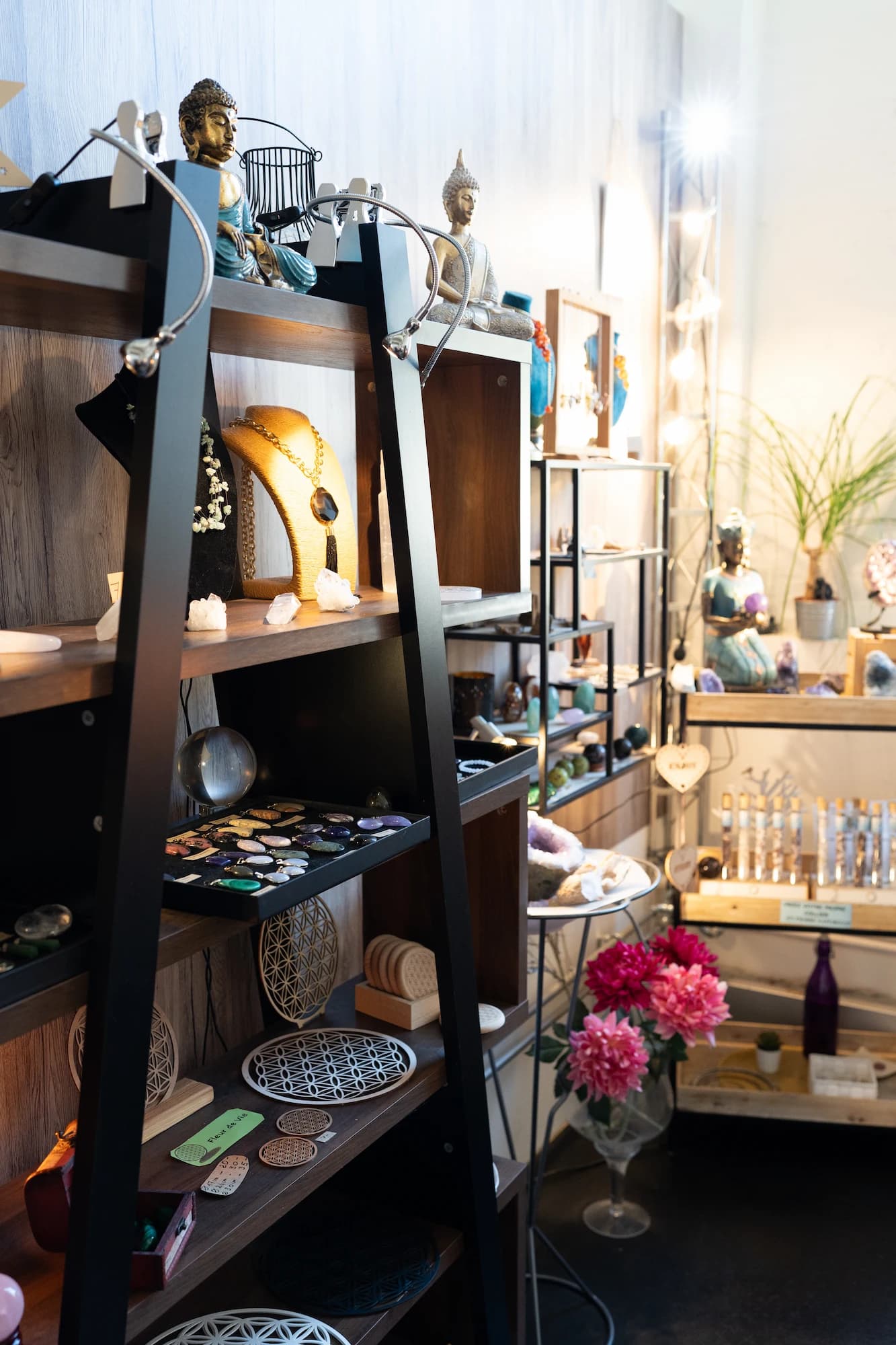 Étagère d'une boutique bien-être avec statuettes Buddha, cristaux et bijoux – shooting photo Novacom Agency