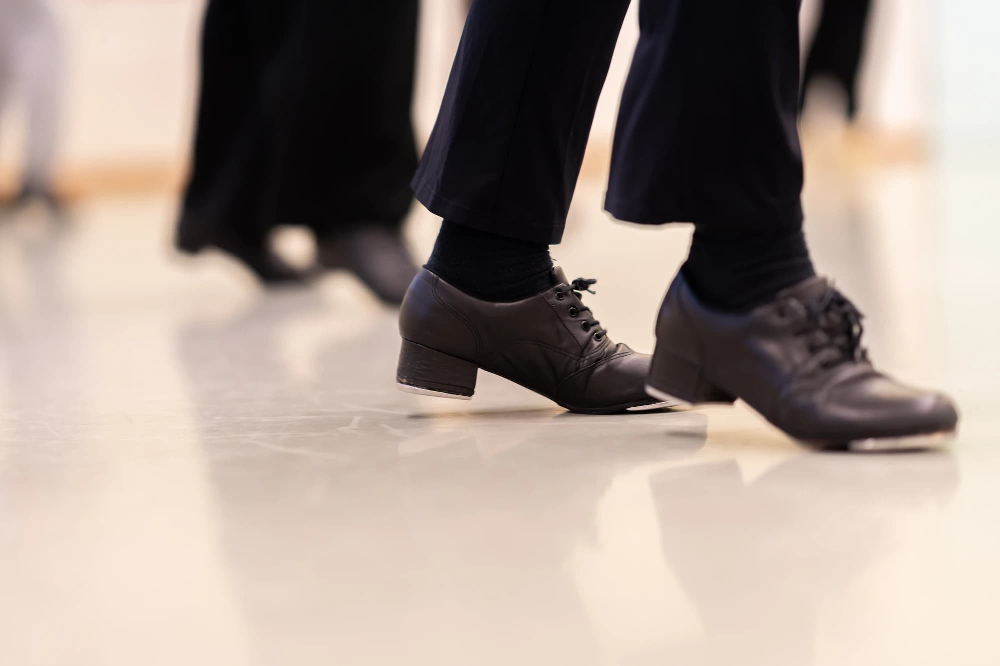Gros plan sur des chaussures de claquettes noires posées sur le sol d'un studio de danse – shooting photo Novacom Agency